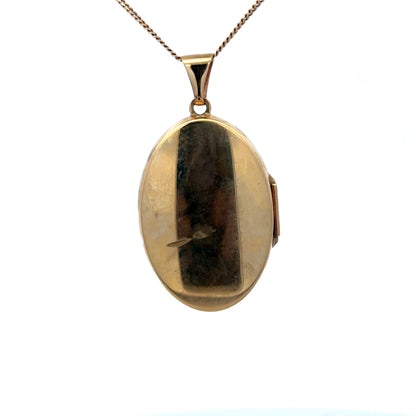 9ct yellow gold locket pendant with floral engraving, Reeves and Sons, 4.4g, showcasing intricate design and polished finish.