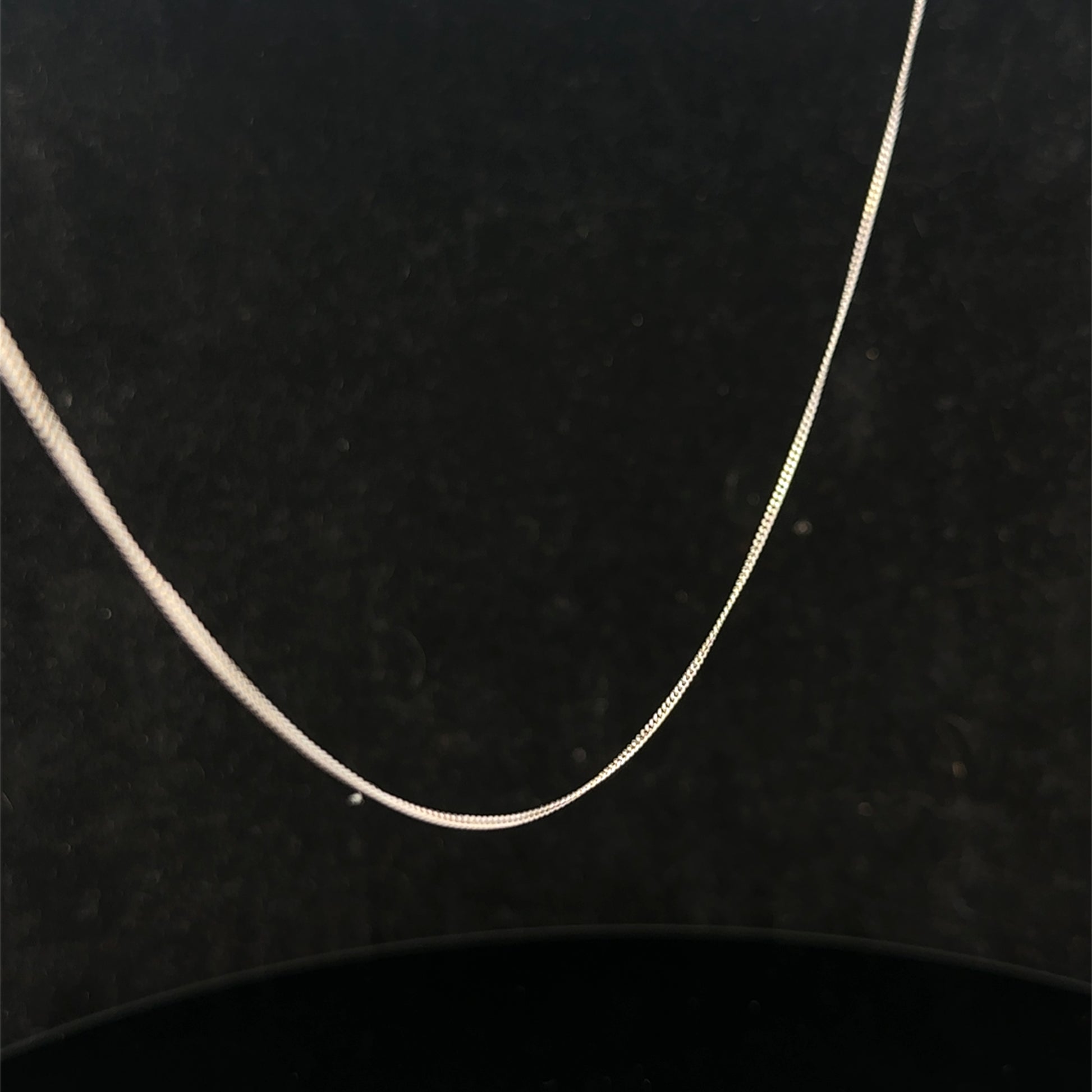 9ct white gold chain by Reeves and Sons, lightweight and elegant jewelry chain, 1.5g in weight, shown in close-up detail.