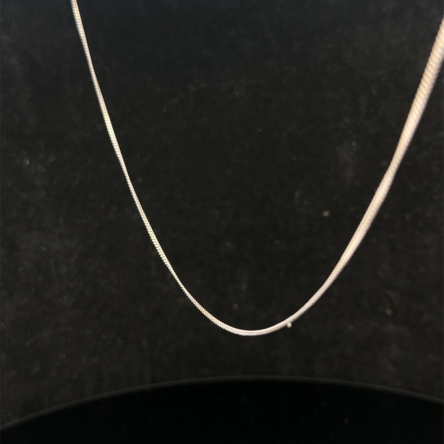 9ct white gold chain weighing 1.5g, featuring a delicate link design from Reeves and Sons, shown in a close-up image.