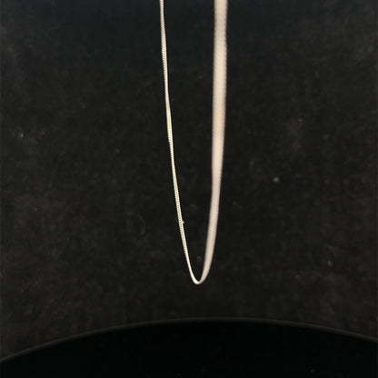 9ct white gold chain weighing 1.5g with a delicate link design from Reeves and Sons, shown in close-up.