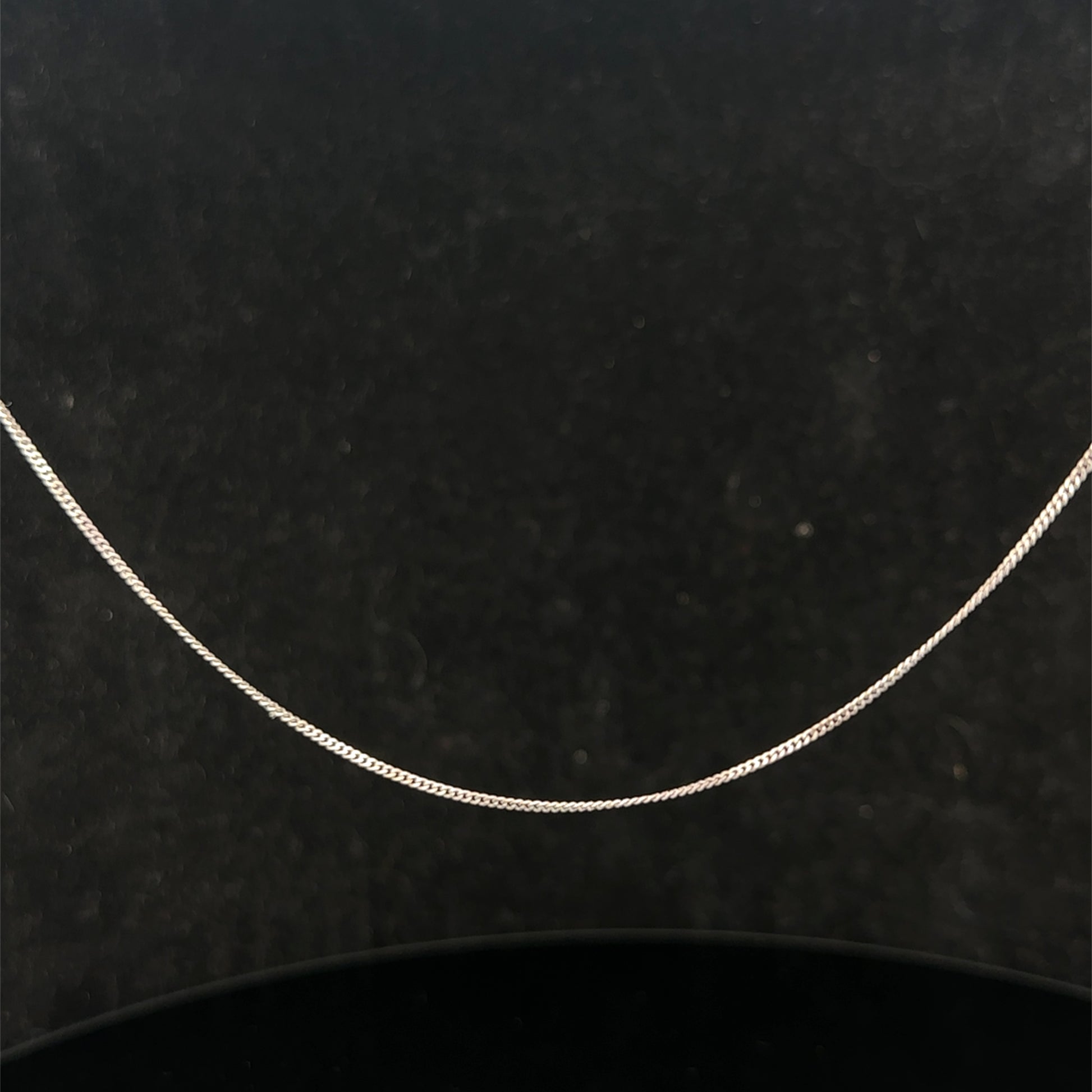 9ct white gold chain from Reeves and Sons, 1.5g, with a delicate link design, shown laying flat on a neutral background.