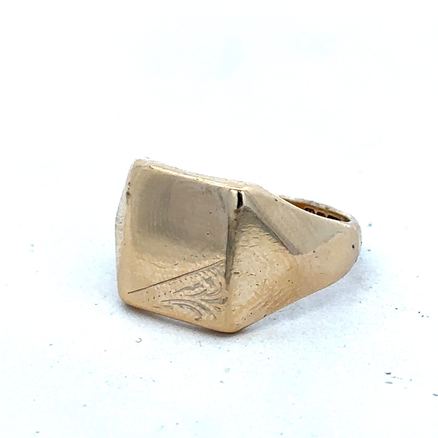 9ct yellow gold signet ring size P1/2 by Reeves and Sons, close-up of polished gold band with engraved face.