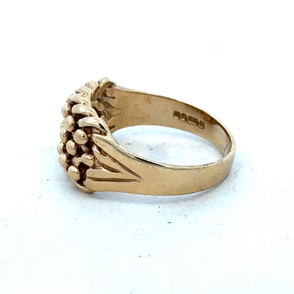 9ct yellow gold keeper ring size T1/2 with a smooth band, crafted by Reeves and Sons, shown in a close-up image.