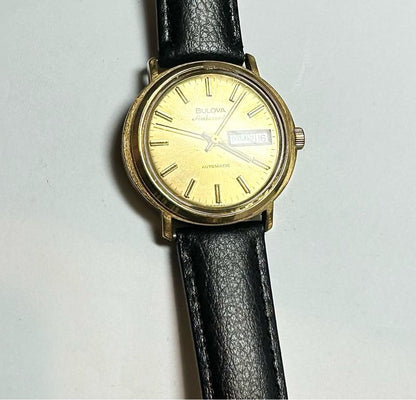 Bulova plated automatic watch with a sleek design, weighing 44.9g, featuring a polished metal finish and classic watch face.