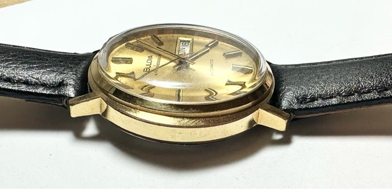 Bulova plated automatic watch with a sleek design, weighing 44.9g, featuring a stainless steel case and a classic dial.