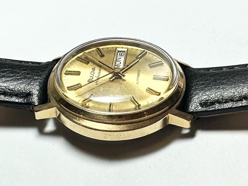 Bulova plated automatic watch with a sleek design, weighing 44.9g, featuring a polished metal finish and classic watch face.