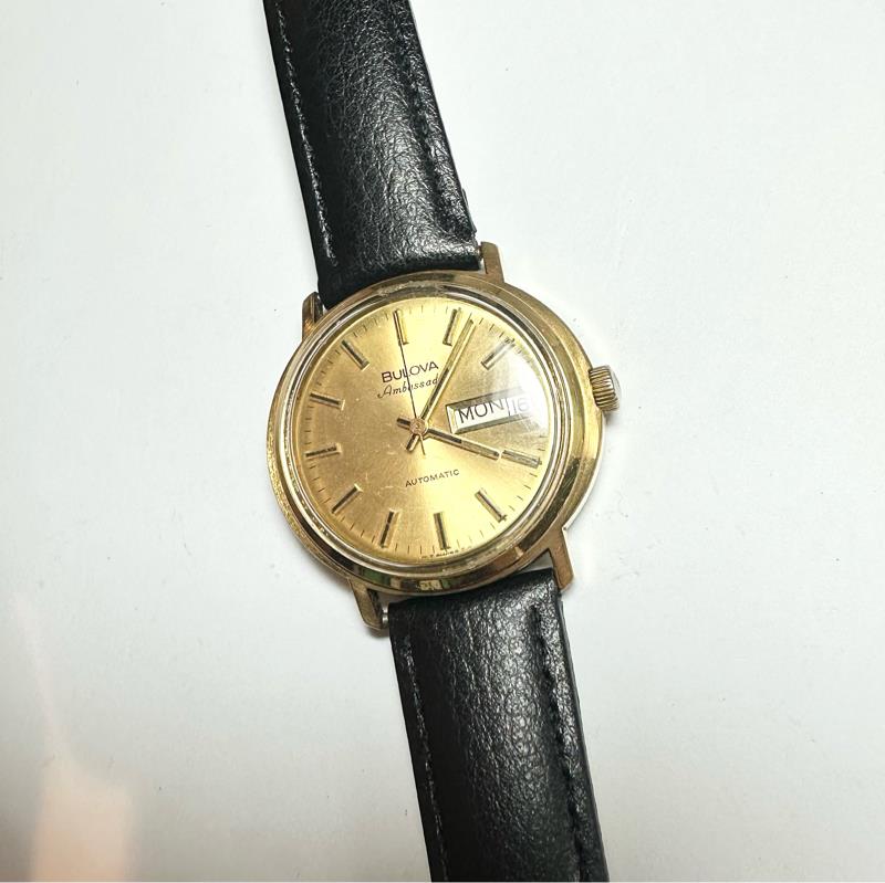 Bulova plated automatic watch with stainless steel case, showcasing a sleek design and visible movement, weighing 44.9 grams.