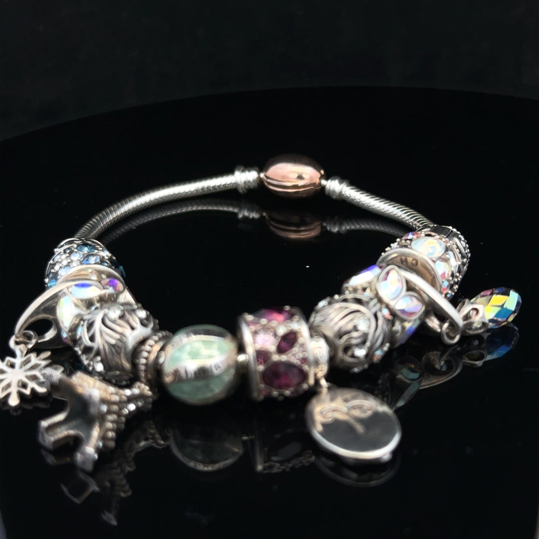 925 silver Chamilia charm bracelet with intricate charms and detailed silver links, showcasing elegant jewelry craftsmanship.