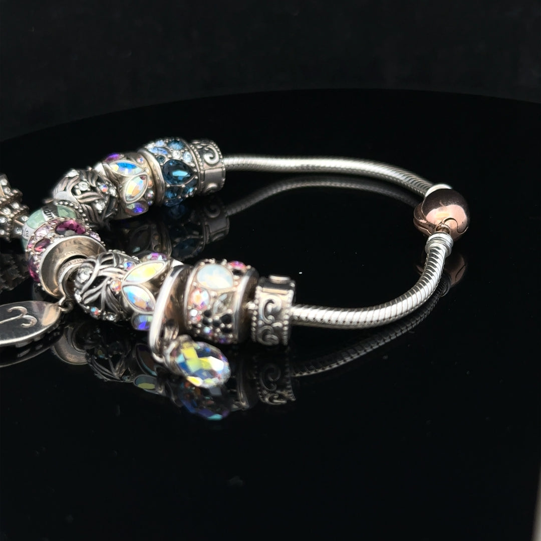 925 silver Chamilia charm bracelet with engraved charms, featuring a sleek design and secure clasp for stylish wear.