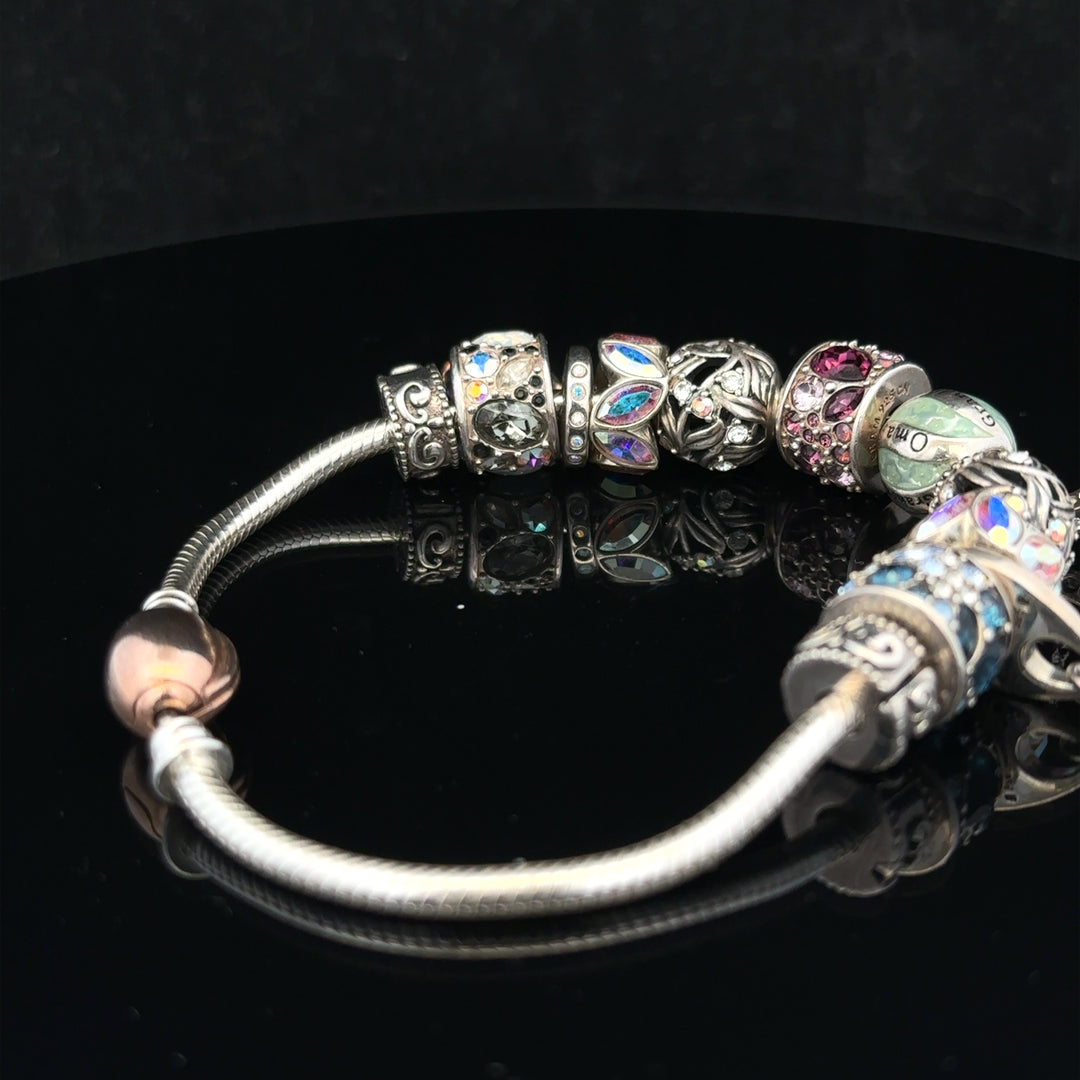 925 silver Chamilia charm bracelet with intricate charms and adjustable link design, crafted for elegant wear.
