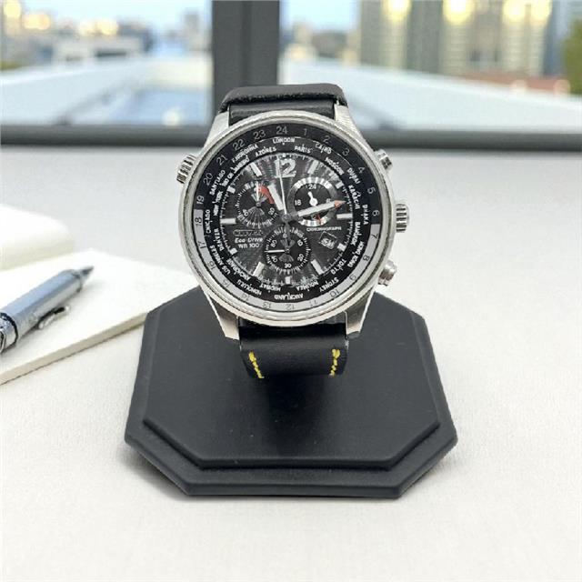 Citizen WR100 Eco-Drive watch with black dial and stainless steel band, featuring date display and water resistance.