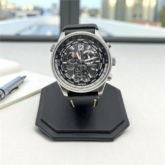 Citizen WR100 Eco-Drive watch with black dial and stainless steel band, featuring date display and water resistance.