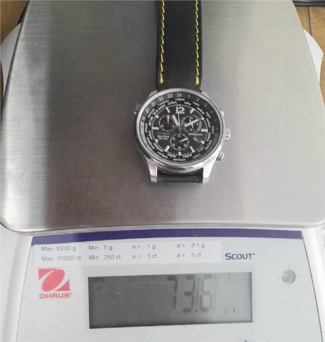 Citizen WR100 Eco-Drive watch with black dial, stainless steel band, and digital display, showing time and date.