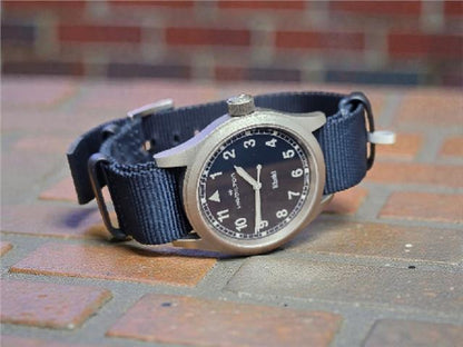 Hamilton Khaki watch Age 2025 with a stainless steel case, black dial, and leather strap, showcasing a classic military design.