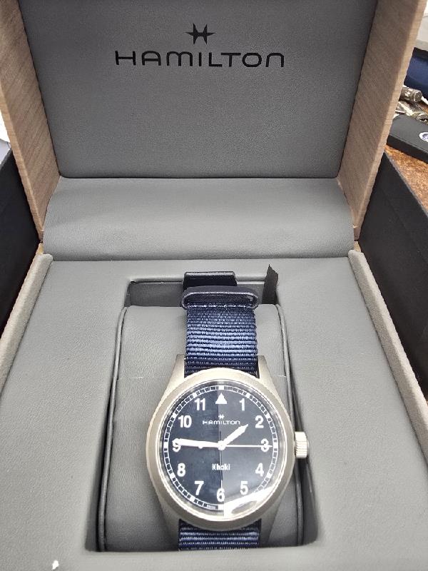 Hamilton Khaki watch Age 2025, men's watch with black dial, stainless steel case, and leather strap.