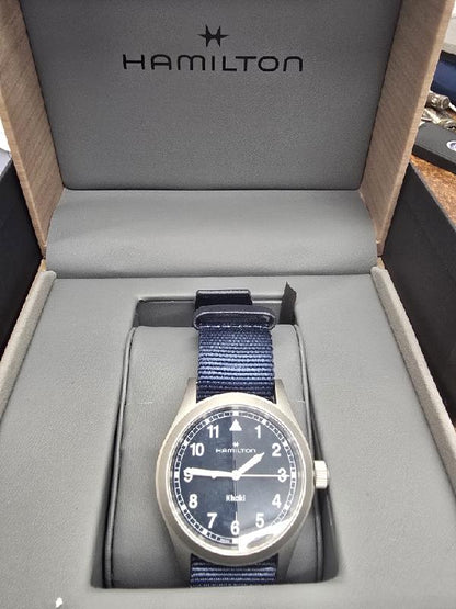 Hamilton Khaki watch Age 2025, men's watch with black dial, stainless steel case, and leather strap.