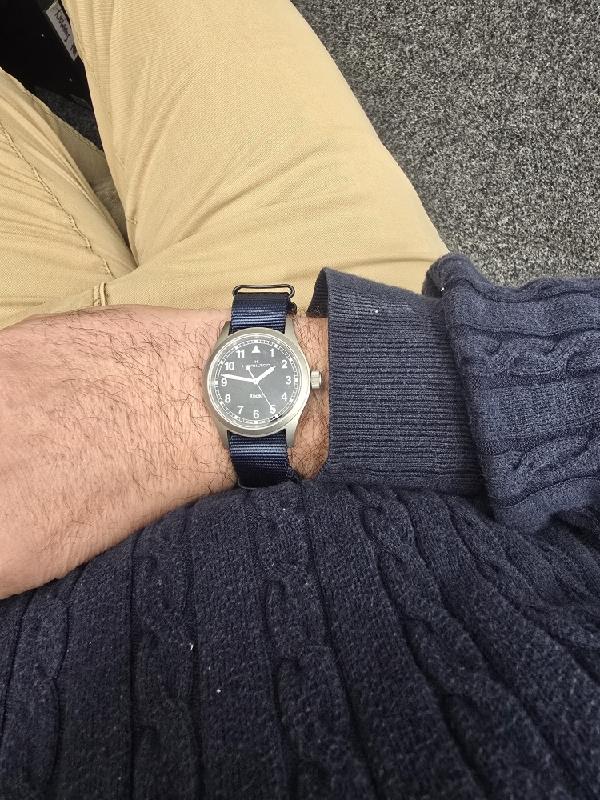 Hamilton Khaki watch Age 2025 with black dial, stainless steel case, and NATO strap, showcasing a classic military-inspired design.