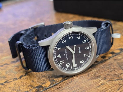 Hamilton Khaki watch Age 2025 with black dial, stainless steel case, and leather strap, displayed on a white background.