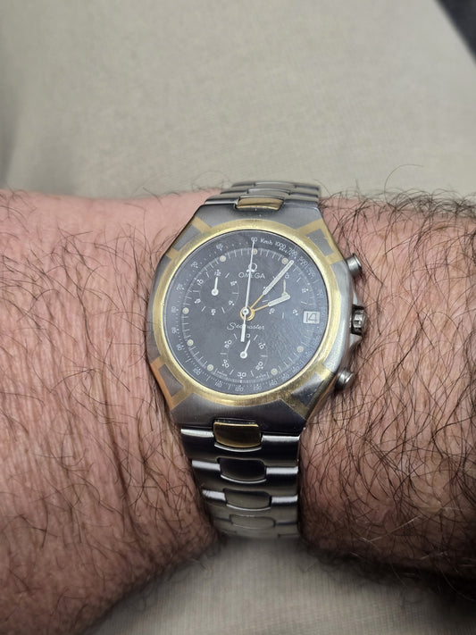 Omega Seamaster Polaris Chronograph watch with box and card, featuring a stainless steel bracelet and detailed dial.