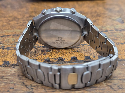 Omega Seamaster Polaris chronograph watch with box and card, featuring a stainless steel case and black dial.