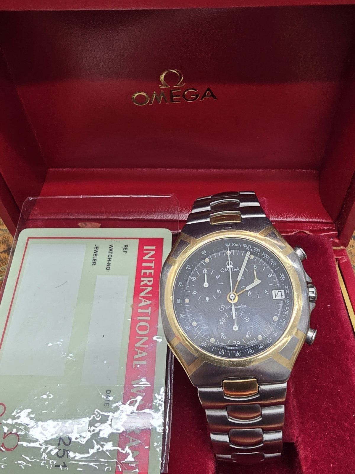 Omega Seamaster Polaris Chronograph watch with box and card, showcasing its stainless steel case and chronograph dial.