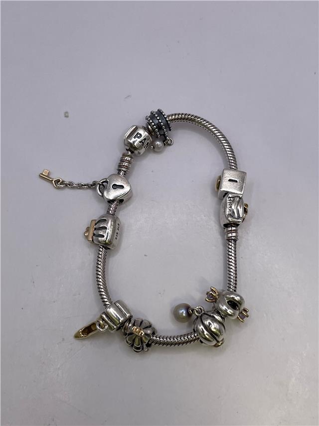 Silver Pandora bracelet with intricate design, weighing 42.3 grams, featuring a polished finish and detailed craftsmanship.