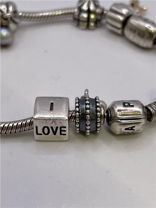 Silver Pandora bracelet with intricate design, featuring a secure clasp and polished finish, weighing 42.3 grams.