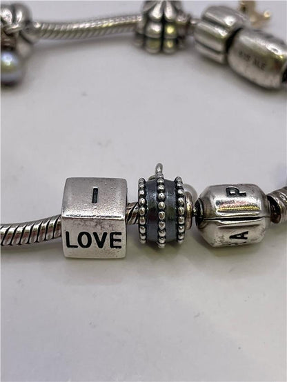 Silver Pandora bracelet with intricate design, featuring a secure clasp and polished finish, weighing 42.3 grams.