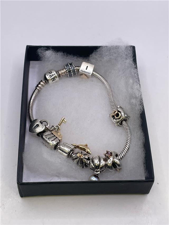 Silver Pandora bracelet with intricate design, weighing 42.3 grams, featuring branded elements and detailed craftsmanship.
