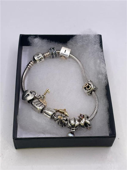 Silver Pandora bracelet with intricate design, weighing 42.3 grams, featuring branded elements and detailed craftsmanship.