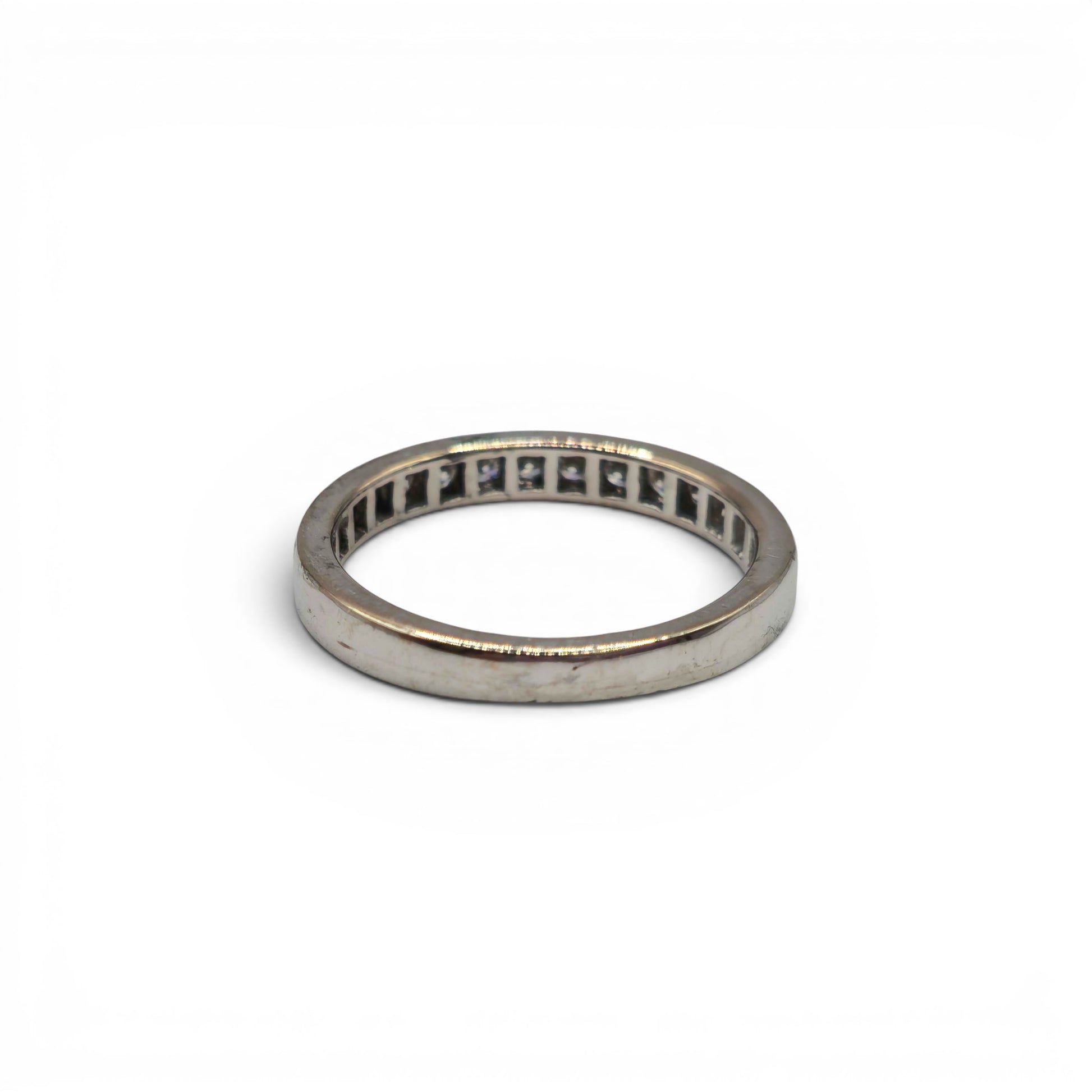 18ct white gold half eternity diamond ring by Reeves and Sons featuring a row of sparkling diamonds on a sleek band.