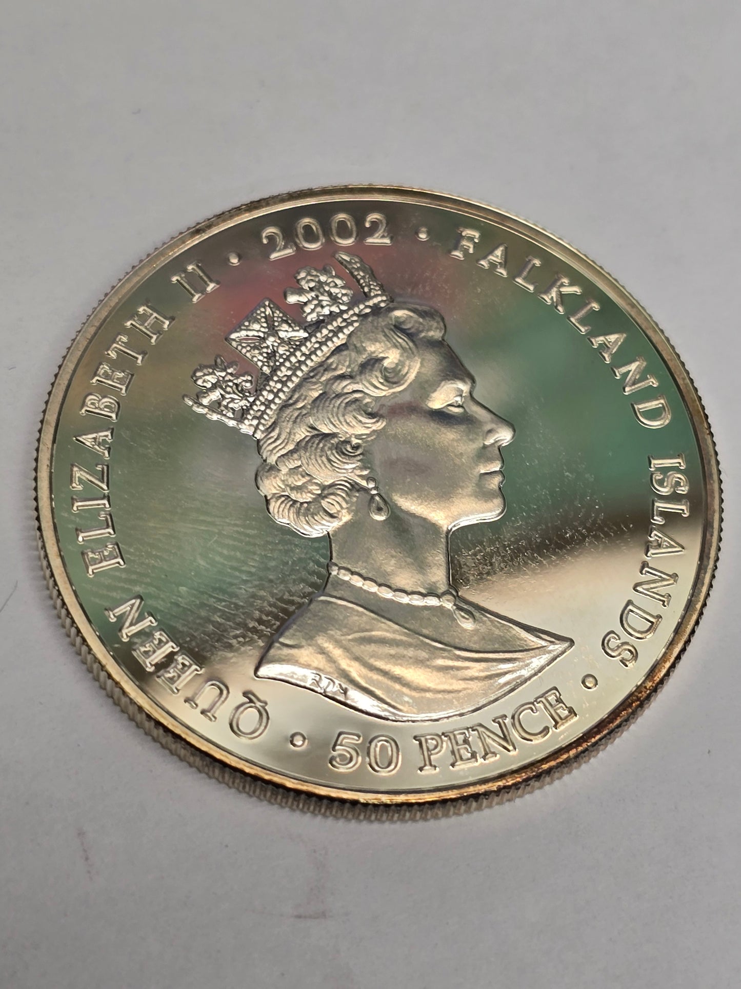 Silver 50 pence golden jubilee coin from 2002 by Reeves and Sons, featuring detailed commemorative design.
