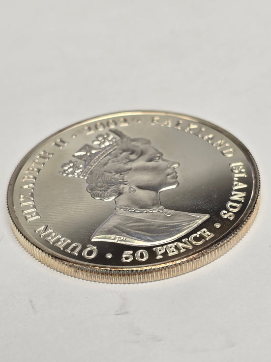 Silver 50 pence golden jubilee coin from 2002 by Reeves and Sons, showing detailed design on a shiny silver surface.