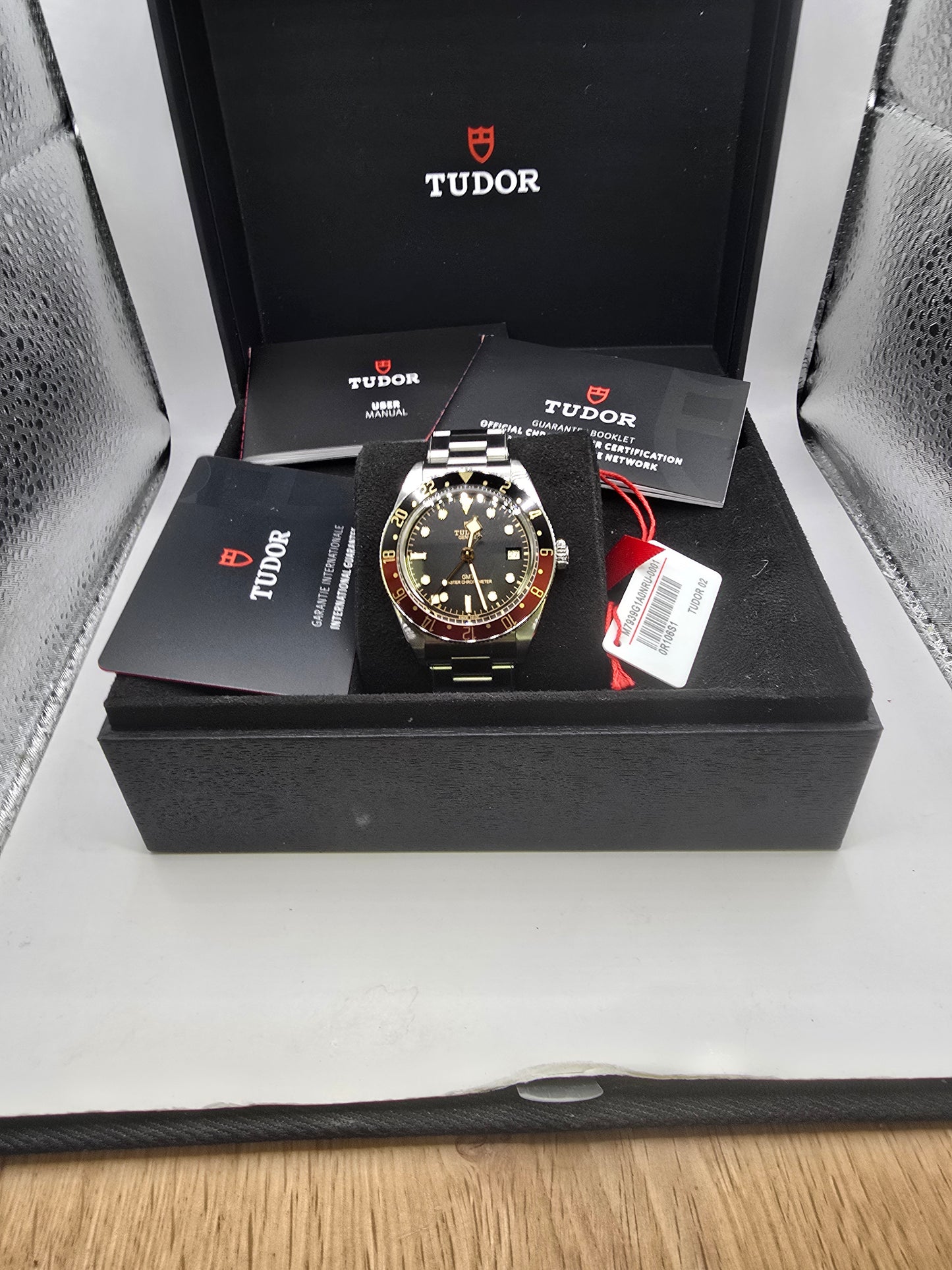 Tudor Black Bay 58 GMT Coke fullset watch from 2024 with black and red bezel, stainless steel bracelet, and detailed dial.