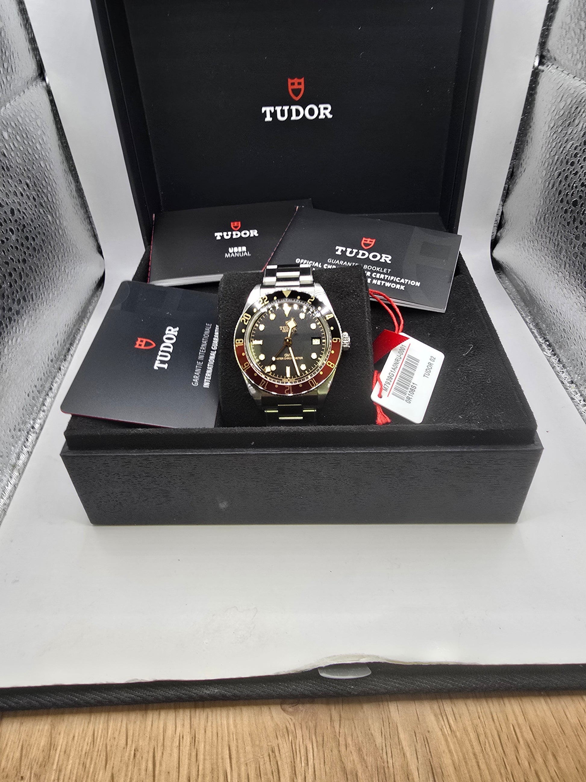 Tudor Black Bay 58 GMT Coke fullset watch from 2024 with black and red bezel, stainless steel bracelet, and detailed dial.