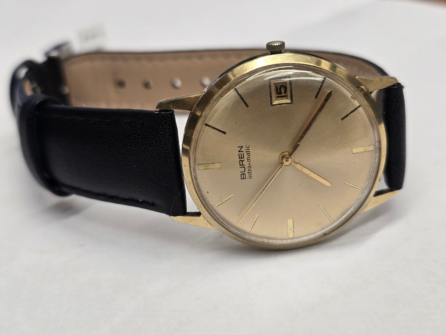 Reeves and Sons Vintage Buren Intra-Matic automatic men's watch with gold plating, sunburst dial, and date display.