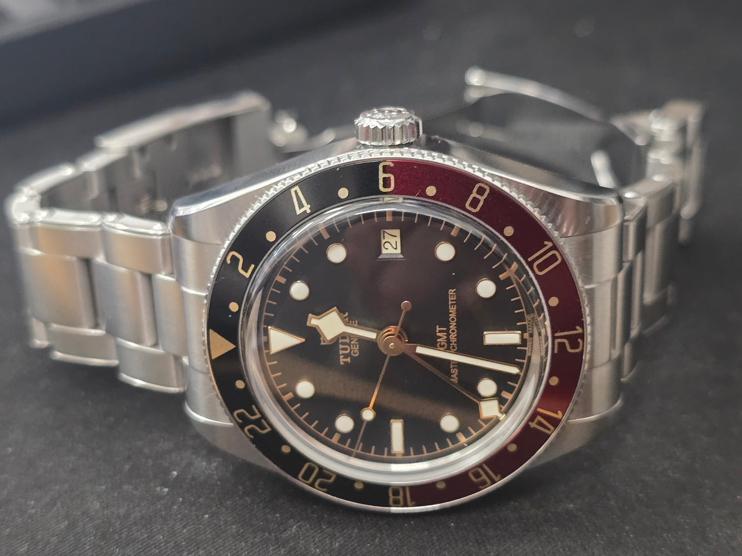 Tudor Black Bay 58 GMT Coke fullset watch from 2024 with black and red bezel, stainless steel bracelet, and detailed dial.