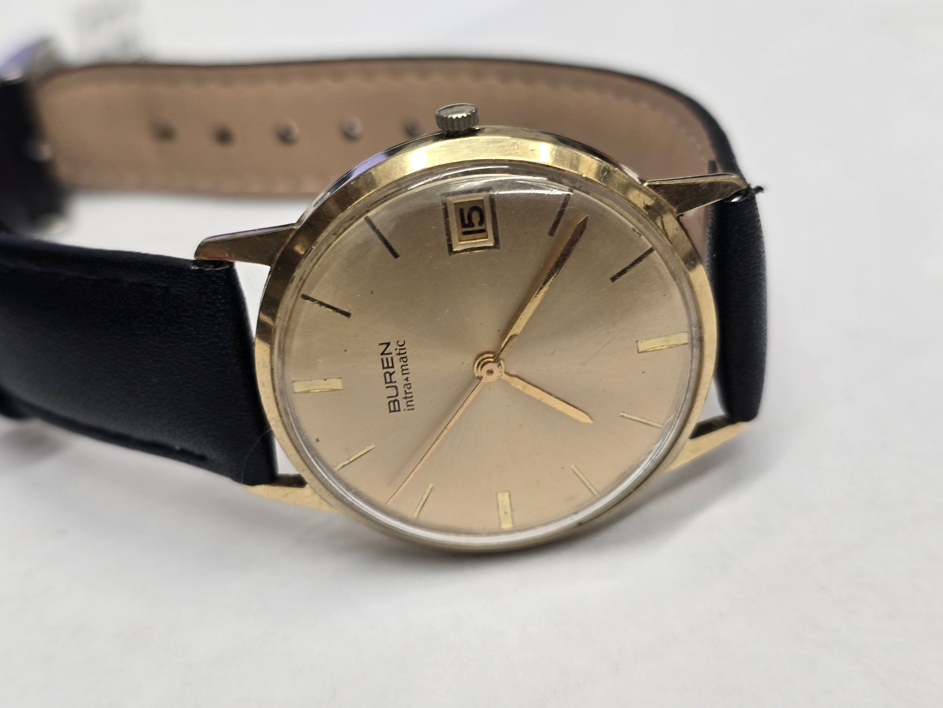 Reeves and Sons Vintage Buren Intra-Matic automatic men's watch with gold plating, sunburst dial, and date display.