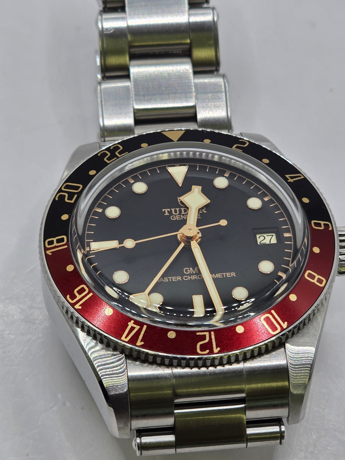 Tudor Black Bay 58 GMT Coke fullset watch from 2024, featuring a black and red bezel and stainless steel bracelet.