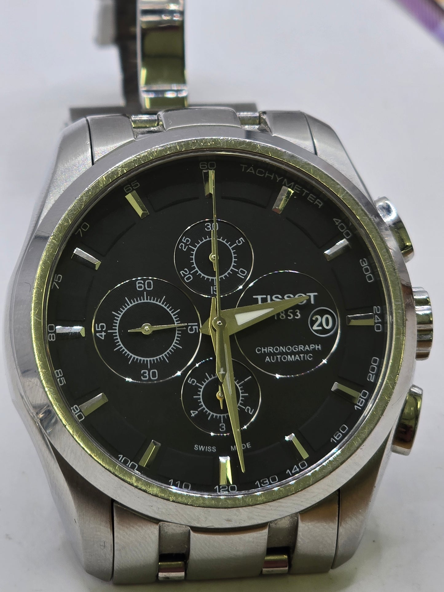 Tissot 1853 automatic chronograph watch with black dial and stainless steel bracelet, showcasing a sleek, modern watch design.