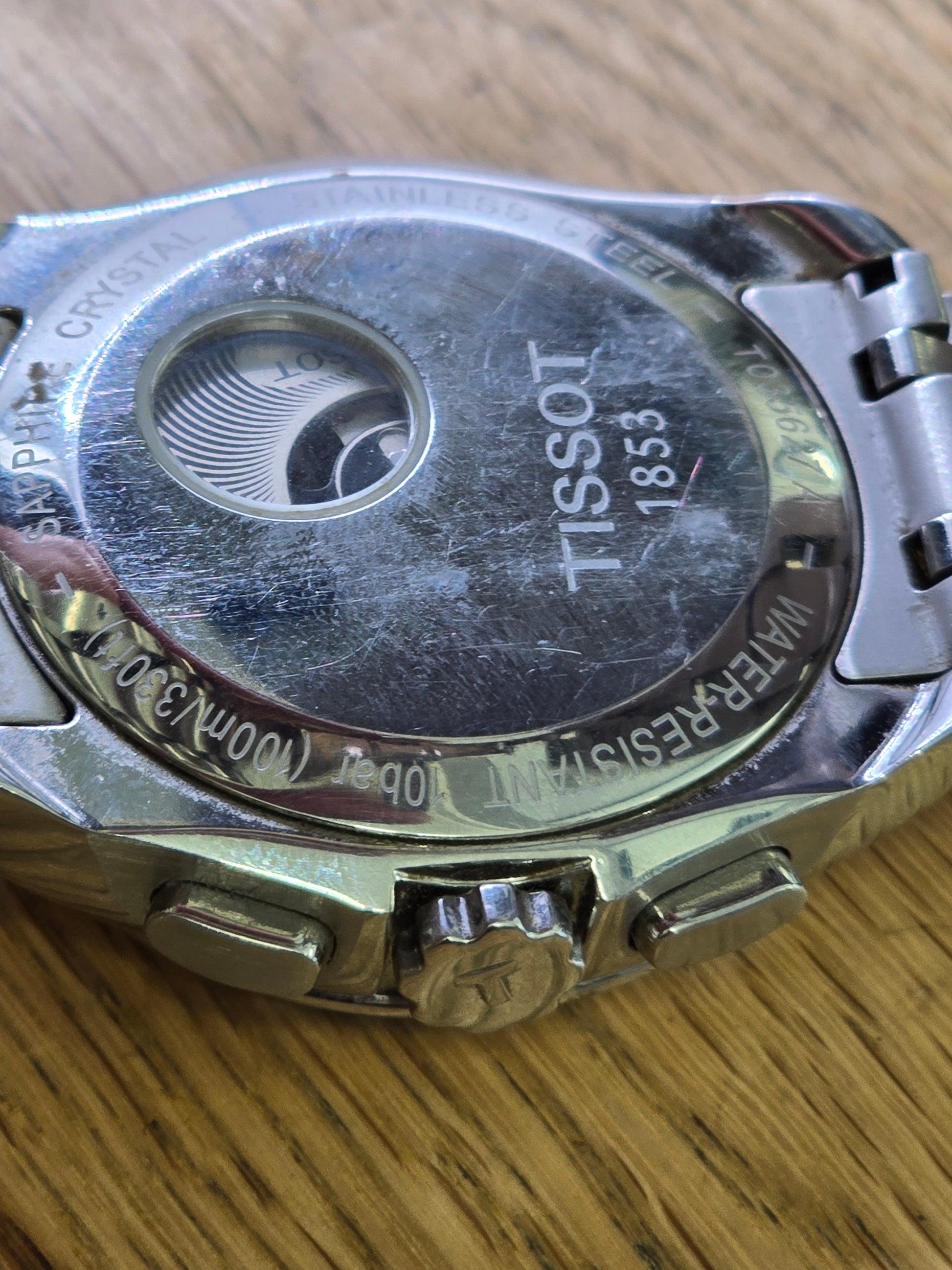 Tissot 1853 automatic chronograph watch with black dial and stainless steel bracelet, showcasing its elegant design.