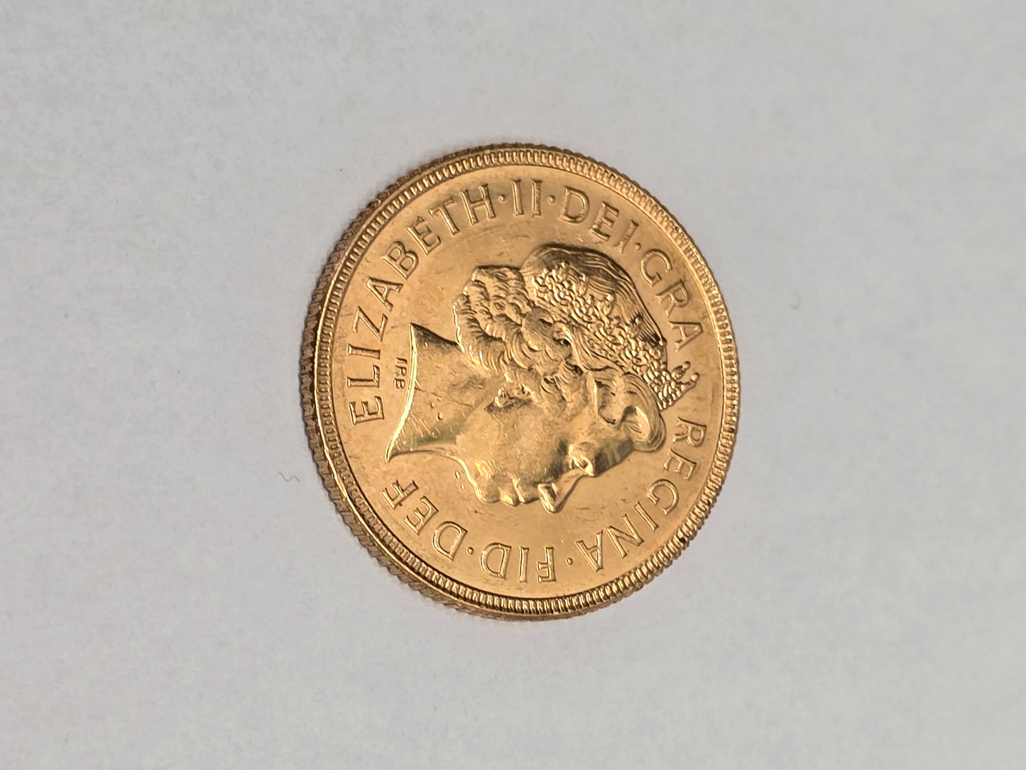 2001 Reeves and Sons full sovereign coin with detailed design and historic engravings, showcasing its classic gold appearance.