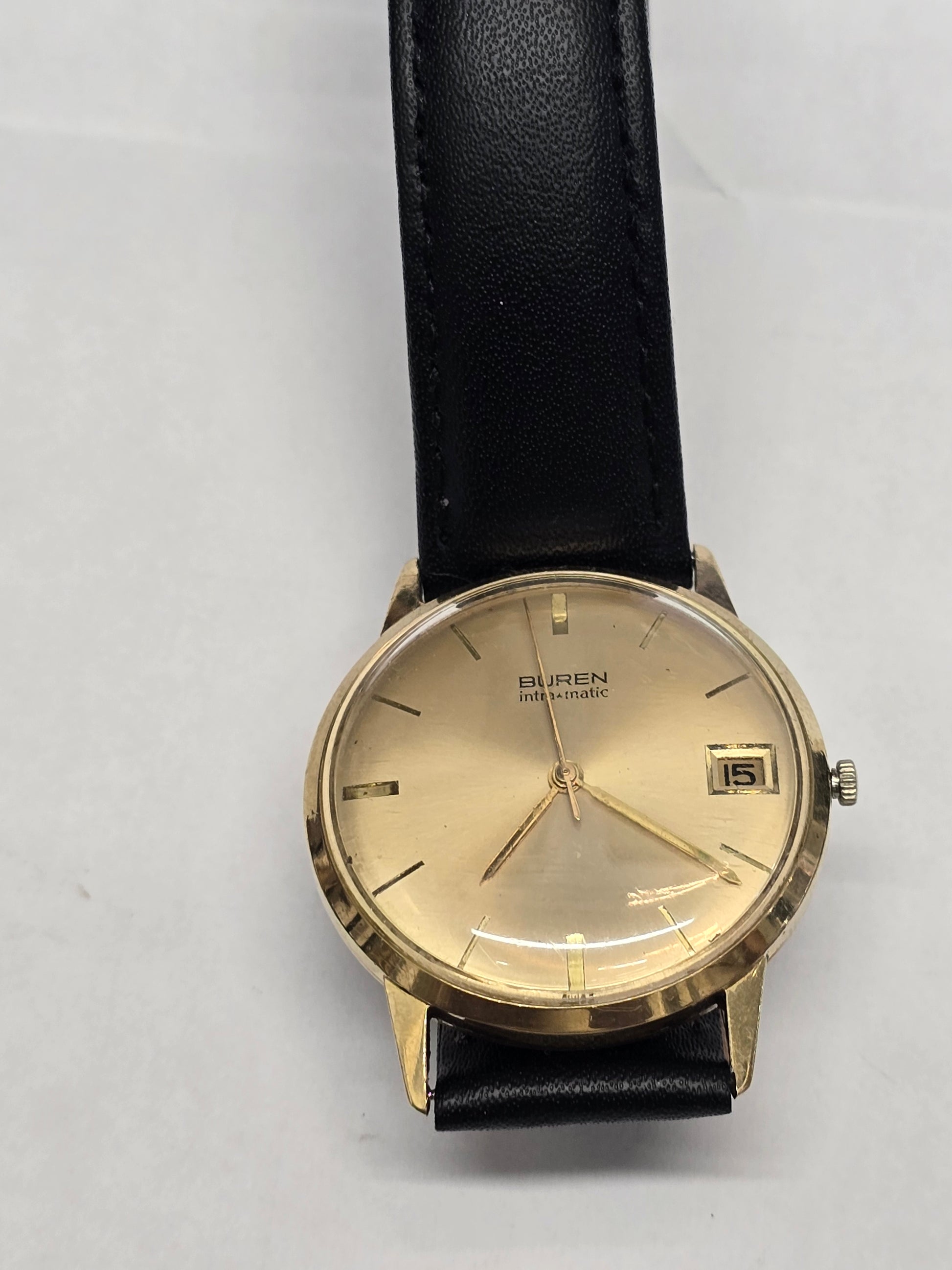 Reeves and Sons Vintage Buren Intra-Matic automatic men's watch with gold plating, sunburst dial, and date display.