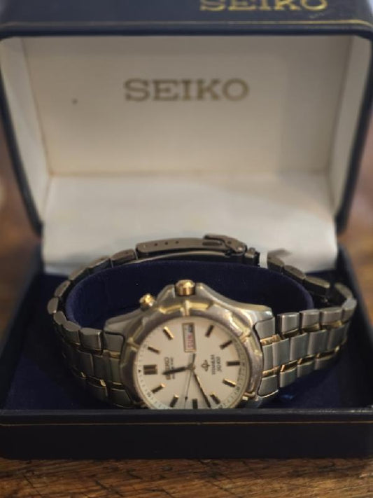 Seiko Kinetic Titanium SQ100 watch with silver dial and black strap, showcasing the sleek, modern design of this Seiko timepiece.