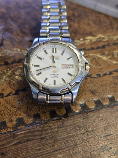 Seiko kinetic titanium SQ100 watch with black dial and stainless steel band, showcasing a sleek, modern design.