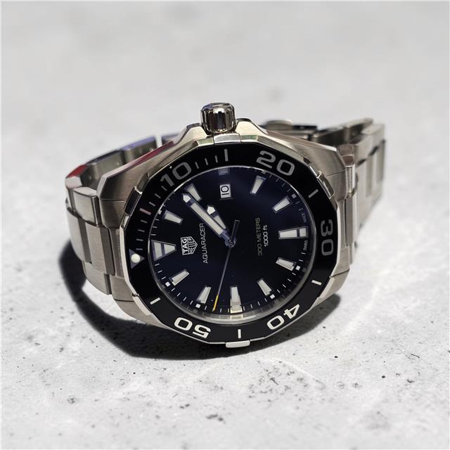 TAG Heuer Aquaracer 300M watch with black dial, stainless steel bracelet, and unidirectional bezel, designed for diving and water sports.