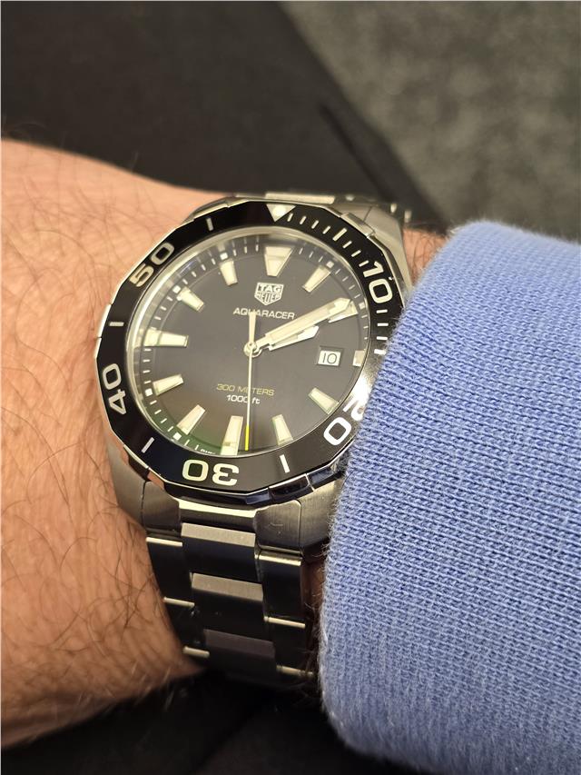 Tag Heuer Aquaracer 300 meters wristwatch with black dial and stainless steel band, designed for diving and water activities.
