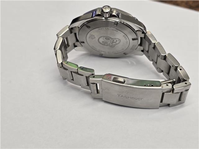 TAG Heuer Aquaracer 300 Meters watch with black dial, stainless steel case, and unidirectional bezel.