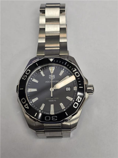 Tag Heuer Aquaracer 300 meters watch with black dial and stainless steel bracelet, suitable for diving and water sports.