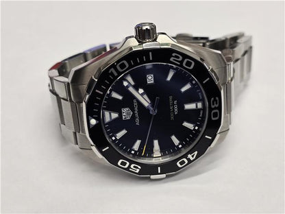 TAG Heuer Aquaracer 300 meters watch with black dial, stainless steel band, and unidirectional bezel.